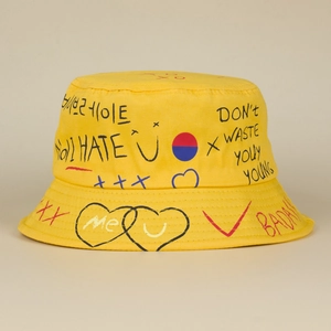 Yellow bucket hat featuring creative hand-drawn graffiti letters and heart prints