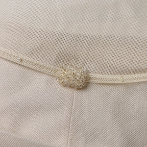 Close-up of fine woven sun hat texture with crystal flowers and pearl embellishments