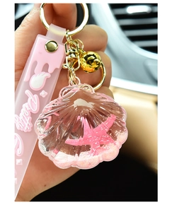 Detailed shot of pink shell liquid keychain with floating starfish and pink hand strap