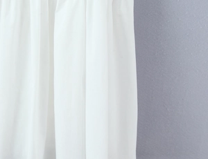 Close-up of white ruched fabric texture on a square neck mini strap dress