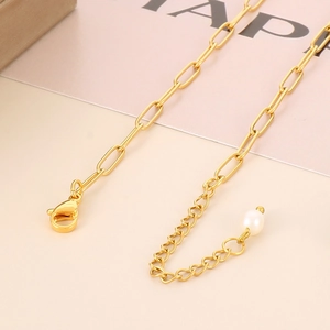 Detail of gold paperclip chain necklace with lobster clasp and pearl extension link