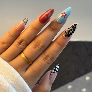 Detailed close-up of almond-shaped press-on nails with leopard and star patterns