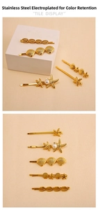 Detailed tile display of five gold stainless steel ocean theme starfish and seashell hairpins