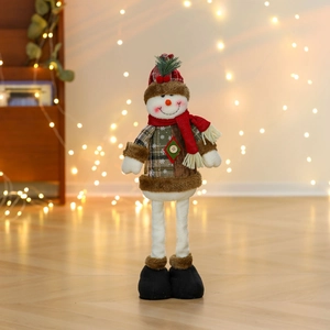 Detail of a standing Christmas snowman doll with red plaid hat on wooden floor