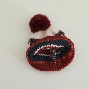 Cappello in maglia accogliente con motivi jacquard e pompon rosso per bambini in inverno