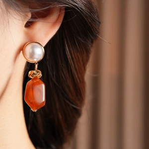 Detail view of vintage irregular resin pearl earrings on a model for an elegant look