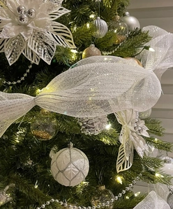 Detail of white mesh ribbon and silver glitter ornaments on Christmas tree decoration