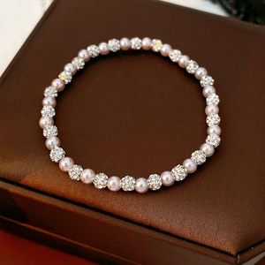Macro view of vintage pearl bracelet with rhinestone paved beads on brown silk fabric