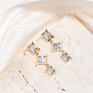 Detail of long gold earrings with cascading square and rhombus clear cubic zirconia