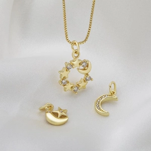 Elegante set di gioielli celesti dorati con ciondoli stella e luna su raso bianco