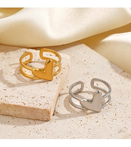 Detail of minimalist open heart rings in gold and silver finish on stone texture