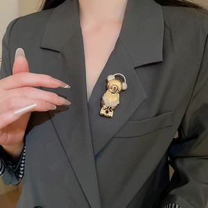 Detailed close-up of a luxury crystal bear brooch pinned on a grey suit lapel