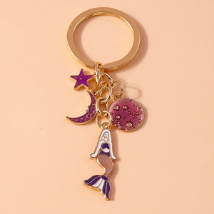 Detail of golden keychain with purple mermaid, star, moon, and constellation charms