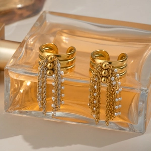Detail of layered gold ear cuff with hanging chains and delicate white pearls