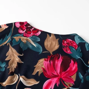 Detailed close-up of retro floral pattern on navy blue v-neck long sleeve dress fabric