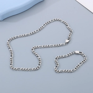 Close-up of silver Figaro chain necklace and bracelet set in polished stainless steel