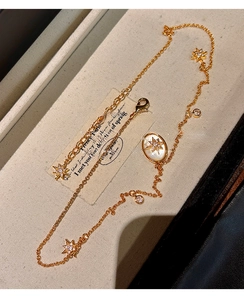 Détail du collier plaqué or 18 carats avec nacre ovale et breloques en forme d'étoile