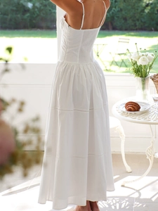 Detail of white maxi dress showing delicate thin straps and ruched back design for summer