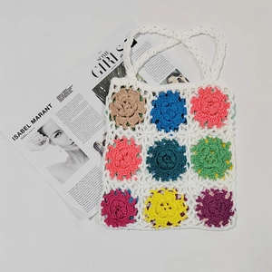 Detail of handmade crochet tote bag featuring nine colorful floral granny square patterns