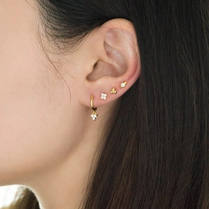 Gold plated S925 silver earrings set with zircon studs shown on a female ear