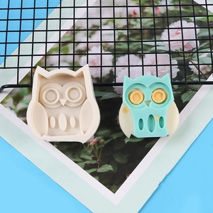Vue détaillée du moule en silicone hibou et savon artisanal bicolore sur une grille