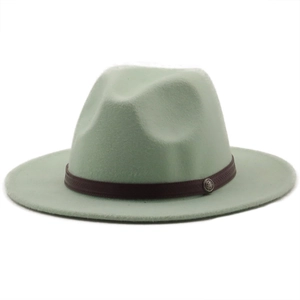 Detail of mint green wool fedora with a brown band and vintage metal badge on white background