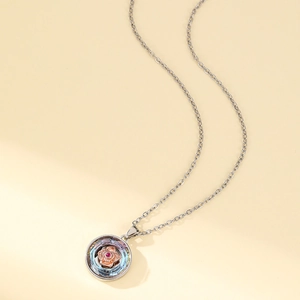 Collier en acier titane avec pendentif fleur en or rose et cristal rouge scintillant