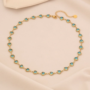 Detail of heart-shaped blue gems on a gold necklace with adjustable lobster clasp closure