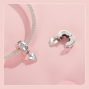 Macro shot of S925 sterling silver heart charm with pink zircon and hallmark detail
