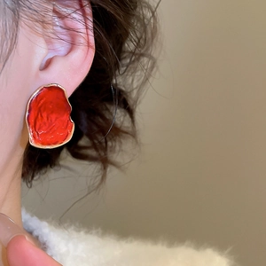 Detailansicht roter unregelmäßiger geometrischer Ohrstecker mit Goldrand am Model