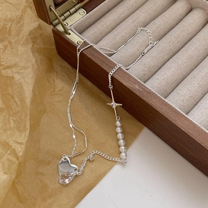 Detailed shot of 925 silver necklace with pearls and zircon on a vintage wooden box
