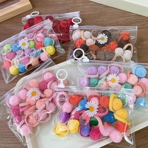 Macaron color plush pom pom hair ties set in daisy zipper bag on wooden background