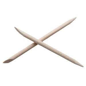Detail of two wooden cuticle pushers with pointed and flat ends on white background