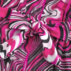 Detail of fuchsia marble print mesh dress showing the tied knot and fabric texture