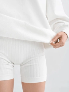 Λεπτομέρεια από λευκό oversized φούτερ με ριμπ σορτς από ύφασμα υψηλής ποιότητας