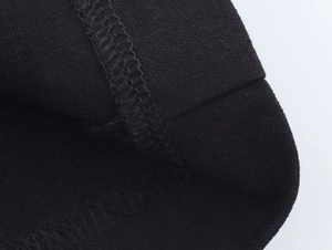 Dettaglio ravvicinato del tessuto a maglia nero con cuciture fini e trama tessile