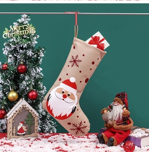 Detail eines beigen Nikolausstiefels mit Weihnachtsmann-Applikation und roten Schneeflocken