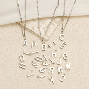 Macro display of assorted silver titanium steel alphabet pendants with chain detail