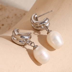 Detail of silver drop earrings featuring unique white baroque pearls with glossy finish