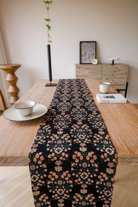 Detailed knit texture of vintage floral pattern table runner on a wooden dining table