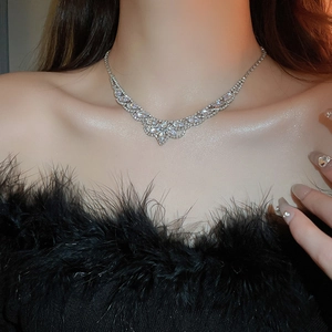 Détail du collier à franges argenté avec strass brillants sur le cou du mannequin