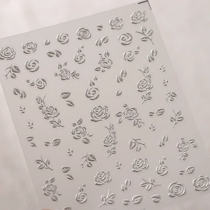 Dettaglio macro di adesivi per unghie 3D con rose argentate in rilievo metallico