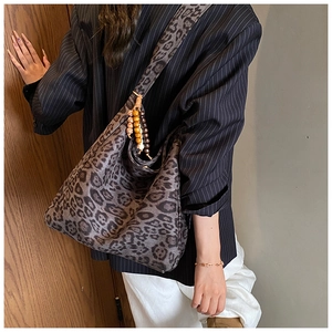 Detail of leopard print shoulder tote bag with bohemian wooden bead tassel ornament