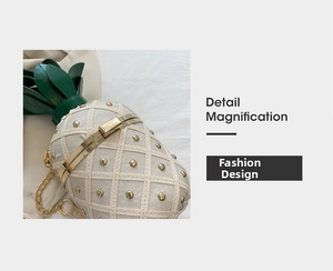 Detailed macro of pineapple bag featuring gold rivets and elegant metal chain strap