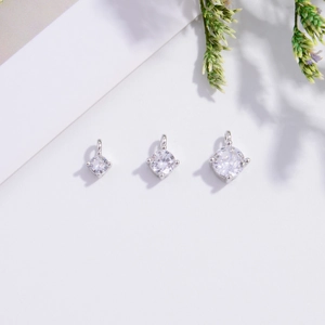 Macro detail of three S925 silver pendants with round zirconia in varying sizes
