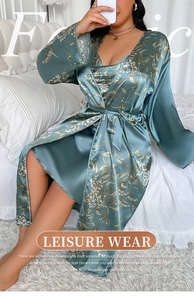 Detail of plus size satin sleepwear set featuring floral prints and a belted robe