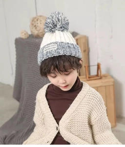 Detailed knit texture and soft pom-pom on children's warm white and grey winter beanie