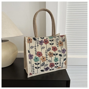 Detailed texture of linen tote bag with colorful vintage floral print and braided handles