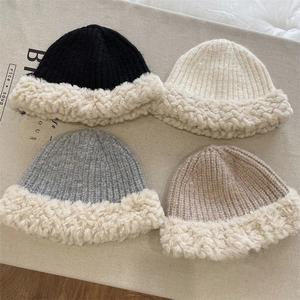 Detailed flat lay of warm knit hats in black, white, grey, and beige with plush trim
