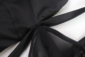 Détail des coutures en maille noire et du tissu élastique sur la robe moulante sexy